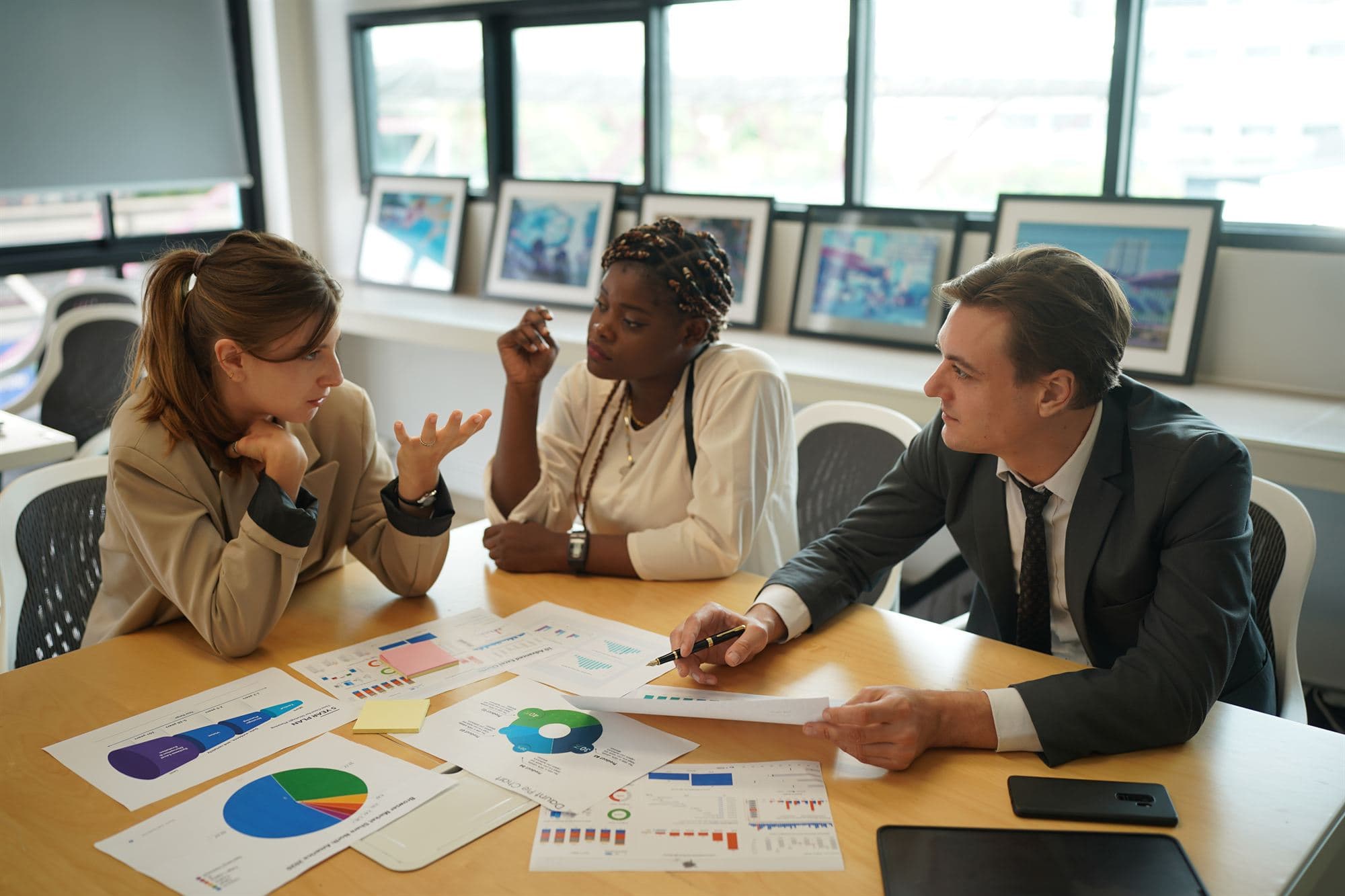 Réunion de travail entre conseillers et clients autour de tableaux financiers