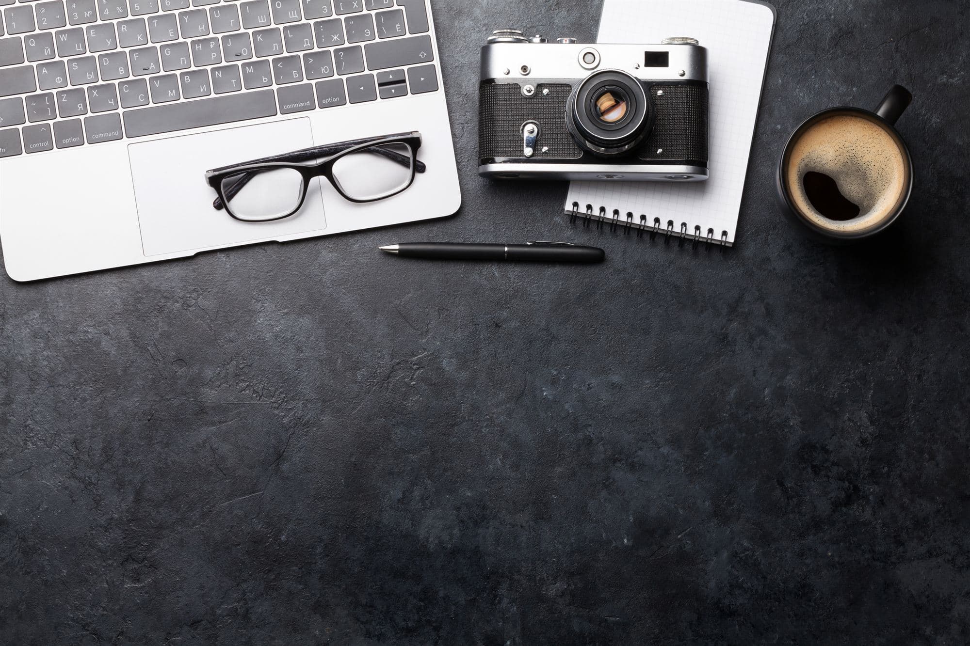 Bureau de travail avec ordinateur, lunettes et carnet